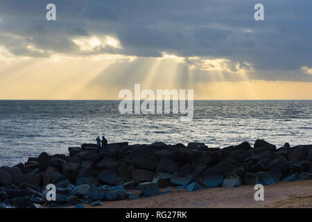 West Bay, Dorset, UK. 27 janvier 2019. Météo britannique. Poutres apparentes du soleil à travers les nuages au-dessus de la baie de l'Ouest dans le Dorset par une froide après-midi breezy Photo Credit : Graham Hunt/Alamy Live News Banque D'Images