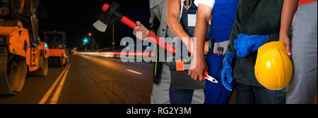 Les travailleurs du constructeur avec la réparation d'un équipement road Banque D'Images