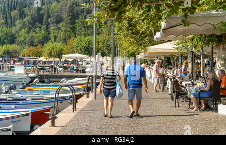 GARDA, ITALIE - Septembre 2018 : Deux personnes marchant le long de la promenade en garda sur le lac de Garde. Banque D'Images