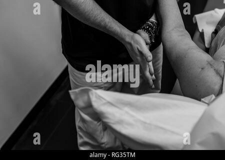 Un homme blanc italien, travaillant comme phisiotherapist est photographié alors qu'au travail tout au long de la dat dans un hôpital en Italie. Banque D'Images