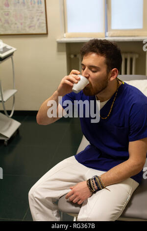 Un homme blanc italien, travaillant comme phisiotherapist est photographié alors qu'au travail tout au long de la dat dans un hôpital en Italie. Banque D'Images