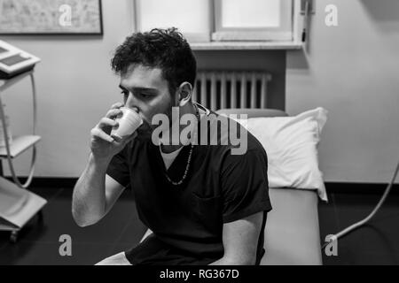 Un homme blanc italien, travaillant comme phisiotherapist est photographié alors qu'au travail tout au long de la dat dans un hôpital en Italie. Banque D'Images