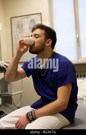 Un homme blanc italien, travaillant comme phisiotherapist est photographié alors qu'au travail tout au long de la dat dans un hôpital en Italie. Banque D'Images