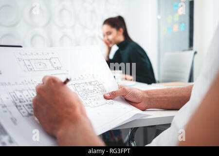 Deux concept design architect blueprint. Jeune homme et femme designer esquisses d'un projet de construction à l'ordinateur portable et le dessin tout en s'appliquant à l'offi Banque D'Images
