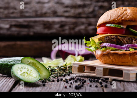 Hamburger frais sur table en bois vieilli, restauration rapide. Vintage table et fond, copy space Banque D'Images