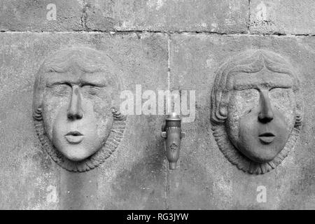 Robinet en bronze avec deux têtes figure de pierre sur un creux de l'eau Barcelone Espagne Banque D'Images