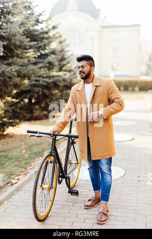Bel homme barbu indiennes autour de son vélo dans la région de city park Banque D'Images