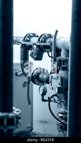 Jeu de tuyaux, les clés et le manomètre, sur fond blanc, noir et blanc photographie industrielle avec une tonalité bleuâtre Banque D'Images