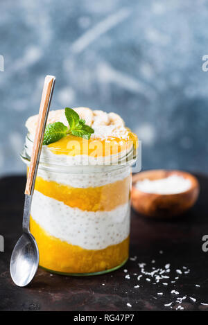 Vegan en couches Chia Pudding à la Mangue dans le bocal. Concept de la saine alimentation, mode de vie sain Banque D'Images