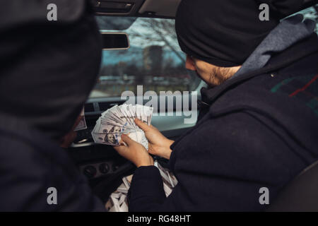 Après le succès du vol de banque, les voleurs sont dans la voiture montrant outre de leur argent et de célébrer la victoire sur le droit qu'ils avaient. Banque D'Images