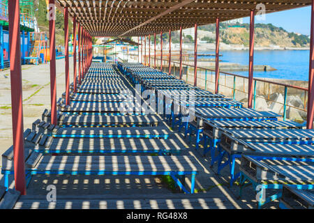 Ancienne en bois de chaises longues sur la plage de Crimée. L'Ukraine Banque D'Images