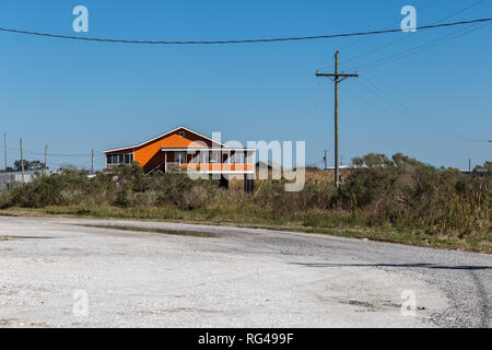 Maison sur pilotis Orange derrière les hautes herbes profondément dans le bayou de la Louisiane avec un ciel bleu clair Banque D'Images