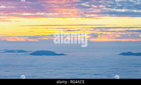 Vue aérienne de nuageux ciel d'hiver, le brouillard et la nébulosité pic de montagne au lever du soleil de Phu Chi Fah, Chaingrai, Thaïlande. Banque D'Images