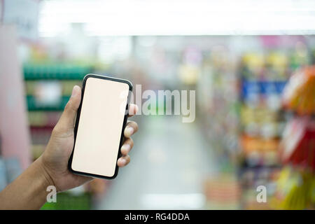 L'homme faisant les courses au supermarché et de scanner un code barre à l'aide de son smartphone, de la technologie et concept de détail - Image Banque D'Images
