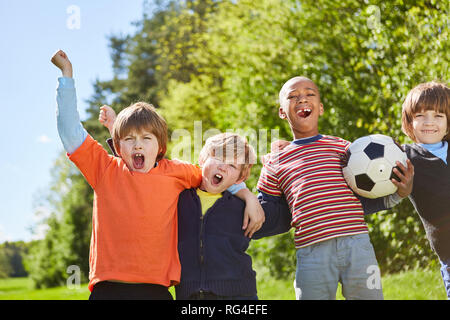 Les enfants dans l'équipe de football multiculturelles s'attendre à une victoire dans le tournoi Banque D'Images