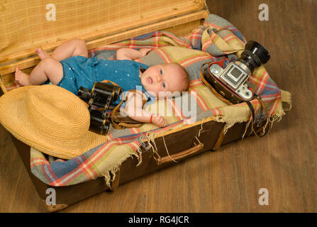 Bébé progressive. La famille. La garde des enfants. Petite fille dans la valise. Voyages et de l'aventure. Portrait of happy petit enfant. Le bonheur de la petite enfance. Photo Banque D'Images