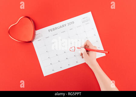 Portrait de femme avec marquage coeur 14 février date à calendar isolé sur rouge, st valentines day concept Banque D'Images