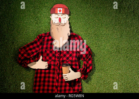 L'homme en carton chemise à carreaux en holding coffee et showing thumb up signe sur fond d'herbe verte Banque D'Images