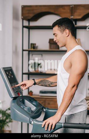 Bel homme bi-raciale du capteur de pression du bouton du panneau de tapis roulant Banque D'Images