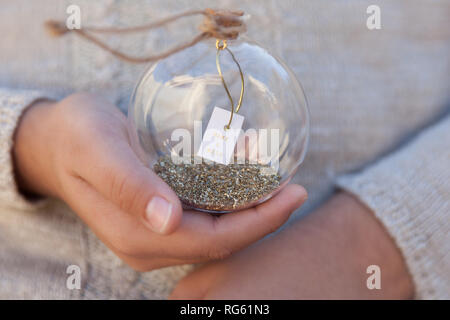 Jeune fille tenant une boule en verre avec un message make a wish Banque D'Images