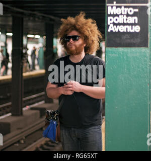 Un homme attend son train dans une station de métro à New York. Banque D'Images