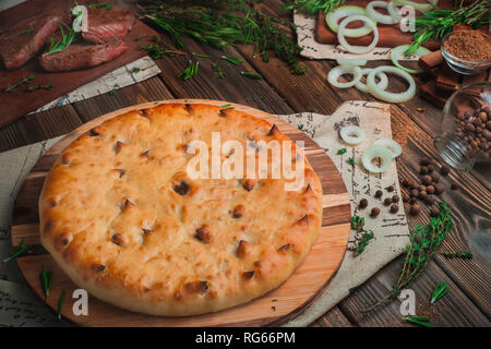 Tourte à la viande de boeuf avec l'Ossétie du Sud sur un fond de bois avec des ingrédients. Boulangerie traditionnelle concept with copy space Banque D'Images