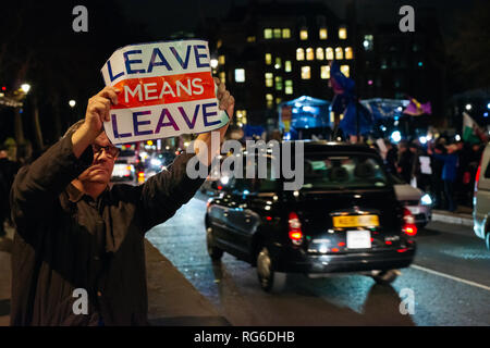 Partisan d'un Brexit holding up a quitter signifie laisser poster devant les Maisons du Parlement, Londres, Royaume-Uni le jour d'un vote le 15 janvier 2019. Banque D'Images