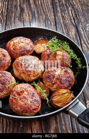 La Turquie, les galettes de poulet frit, escalopes de viande hachée dans une poêle avec le thym, l'ail et l'oignon sur une vieille table en bois, vue verticale d'en haut Banque D'Images