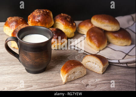 Des brioches et des tartes et d'argile avec du lait en verre Banque D'Images