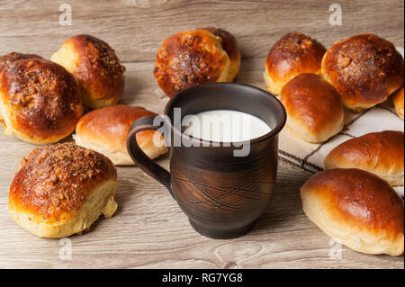 Des brioches et des tartes et d'argile avec du lait en verre Banque D'Images