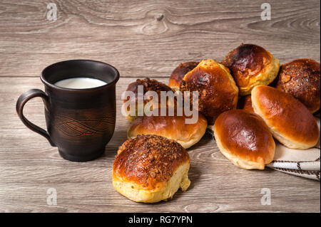 Des brioches et des tartes et d'argile avec du lait en verre Banque D'Images