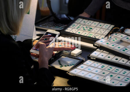 Ramat Gan, Israël. 28 janvier, 2019.Un commerçant utiliser son téléphone intelligent pour inspecter les pierres précieuses à la parquet de la Israel Diamond Exchange (IDE) au cours de la Semaine internationale du diamant en Israël (IDWI). Des centaines de sociétés diamantaires israéliens offerts les deux diamants non sertis de diamants et bijoux à des acheteurs de diamants de plus de 30 pays à travers le monde à l'événement annuel la grande quantité et variété de produits à l'offre est évaluée à plus de un milliard de dollars. Credit : Eddie Gerald/Alamy Live News Banque D'Images