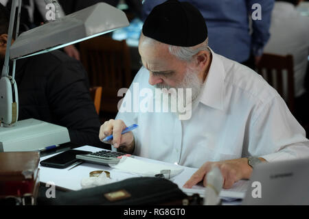 Ramat Gan, Israël, 28 janvier 2019 : un négociant juif religieux ultra orthodoxe vendant des diamants sur le parquet de la Bourse israélienne du diamant (IDE) pendant la semaine internationale du diamant en Israël (IDWI). Des centaines de sociétés diamantaires israéliennes ont offert à la fois des diamants en vrac et des bijoux en diamants à des acheteurs de diamants de plus de 30 pays à travers le monde lors de cet événement annuel, la grande quantité et la variété des produits proposés sont évalués à plus d'un milliard de dollars. Crédit : Eddie Gerald/Alamy Live News Banque D'Images