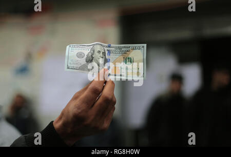 Gaza, la Palestine. 28 janvier 2019. Un Palestinien vu la tenue d'un hundred dollar bill (100) après avoir reçu l'aide du Qatar à l'office de poste dans la bande de Gaza.palestiniens, première phase du fonds d'aide du pays au bureau de poste et le fonds d'aide du Qatar ont été livrés à 44 000 familles dans la bande de Gaza. Credit : Yousef Masoud SOPA/Images/ZUMA/Alamy Fil Live News Banque D'Images