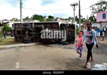 La Havane, Cuba. 28 janvier, 2019. Les gens passent devant un camion renversé dans la zone touchée par une tornade dans la municipalité de Regla à La Havane, Cuba, le 28 janvier 2019. Une puissante tornade a traversé la capitale cubaine le dimanche soir, laissant trois morts et 172 autres blessés. Credit : Joaquin Hernandez/Xinhua/Alamy Live News Banque D'Images