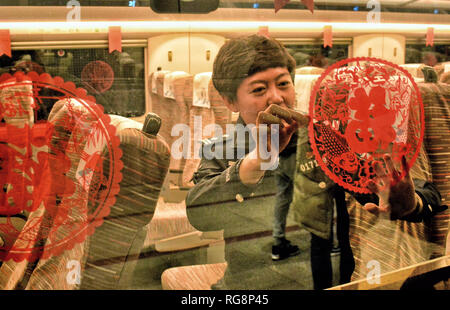 Beijing, Chine. 28 janvier, 2019. Un agent de police s'enfonce un papercutting sur la fenêtre du train G667 à Beijing, capitale de Chine, le 28 janvier 2019. Crédit : Li Xin/Xinhua/Alamy Live News Banque D'Images