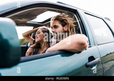 Happy young couple in a car Banque D'Images