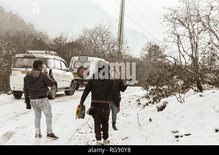 Yumthang Vallée, Sikkim, Inde 1er janvier 2019 : Groupe d'dans des vêtements d'hiver profiter de la neige en neige sur une journée avec beaucoup de neige la pente près de Banque D'Images