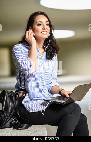 Portrait of smiling with mise sur earphones Banque D'Images