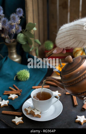 Woman's hand pouring dans une tasse de thé Banque D'Images