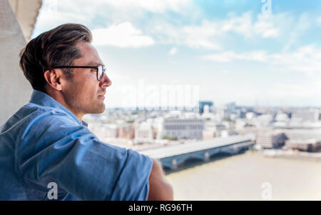 UK, Londres, l'homme à la recherche de la ville, sur un toit-terrasse Banque D'Images