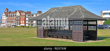 Abri bois traditionnelle sur les sièges et station balnéaire de vacances appartement victorien avec promenade en briques rouges au-delà de Frinton and on Sea Essex UK Banque D'Images