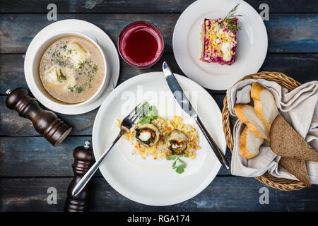 Le déjeuner ensemble. Rouleaux de poisson avec du riz, de la soupe et salade russe traditionnelle avec du hareng. Banque D'Images