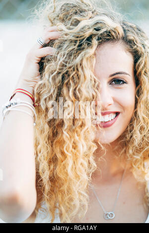 Portrait de jeune femme aux cheveux bouclés blonds Banque D'Images