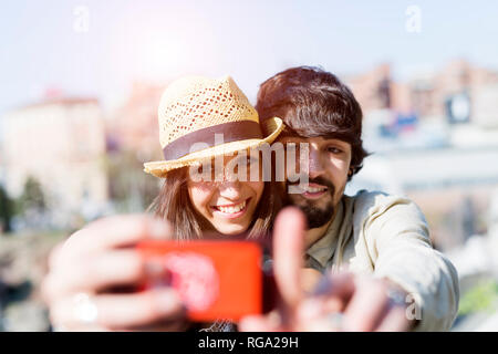 Portrait of happy young couple with smartphone selfies Banque D'Images