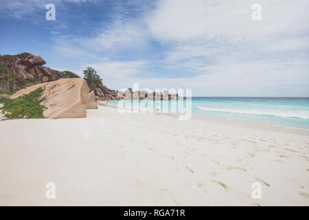 Seychelles, La Digue, Grand Anse, femme marche sur la plage Banque D'Images