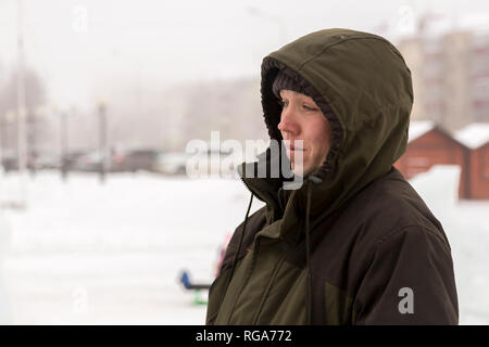 Portrait d'un travailleur de l'assembleur dans une veste avec une capuche à la construction d'un camp de glace Banque D'Images