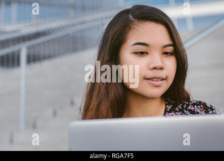 Jeune étudiant au collège contenu asiatique fait ses devoirs sur le campus Banque D'Images