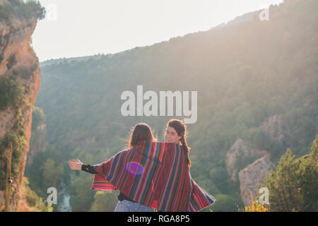 L'Espagne, Alquezar, vue arrière de deux jeunes femmes en randonnée partager une couverture Banque D'Images