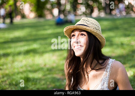 Portrait of happy young woman in a park regarder quelque chose Banque D'Images